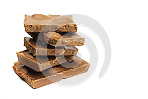 Tower, a stack of milk chocolate chunks with nuts isolated on white