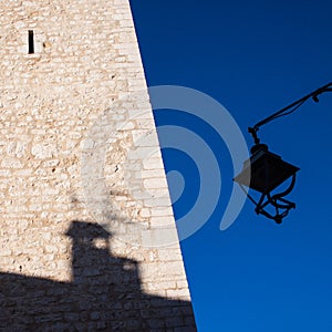 Tower with streetlamp and shadow