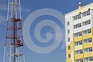 The tower transmits or retransmits radio and television signals and enhances mobile communications near a residential building.