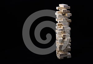 A tower of wooden blocks toy with a black background. The concept of learning and development.