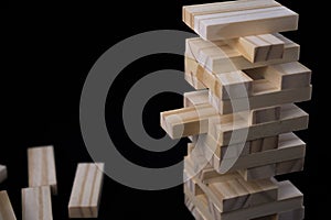 Tower from wooden blocks toy with black background. Learning and development concept.