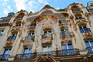 A towering building with numerous windows and balconies, standing tall amidst the urban landscape, Art Nouveau hotel facade in