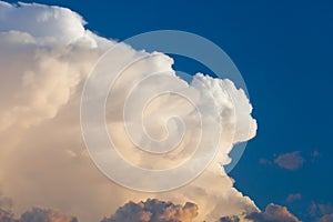 Towering cumulonimbus thunderstorm cloud with blue sky in the ba