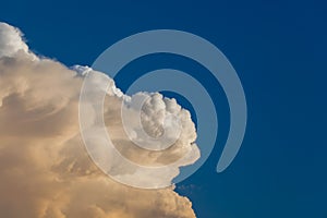 Towering cumulonimbus thunderstorm cloud with blue sky in the ba