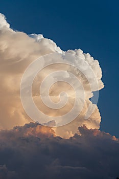 Towering cumulonimbus thunderstorm cloud with blue sky in the ba