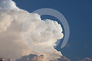 Towering cumulonimbus thunderstorm cloud with blue sky in the ba