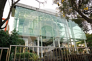 A towering glass building with a unique design and architecture that has its own characteristics is located in the blue sky