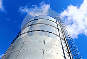Towering grain silo under blue skies.