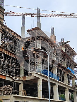 A towering high-rise structure, its steel framework exposed in the nascent stages of construction. photo