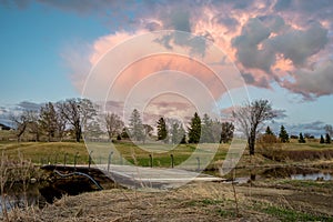 Towering pink sunset cloud over a golf course in Swift Current, SK, Canada photo