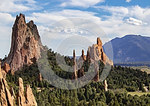 The towering red rock formations of the Garden of the Gods of Colorado Springs with Cheyenne Mountain in the background