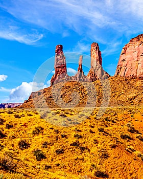 The towering red sandstone formations of the Three Sisters pinnacles and Mitchell Mesa in Monument Valley Navajo Tribal Park photo