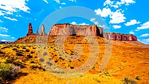 The towering red sandstone formations of the Three Sisters pinnacles and Mitchell Mesa in Monument Valley Navajo Tribal Park photo