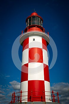 Towering, Tall Lighthouse Against Deep Blue Sky