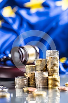 Towers with euro coins flag of European Union and justice hammer in the background