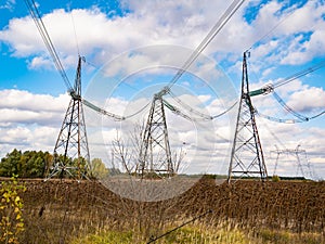 Towers of high-voltage energy transfer against a cloudy sky