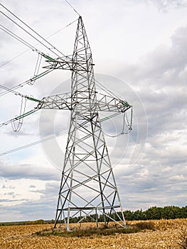 Towers of high-voltage energy transfer against a cloudy sky