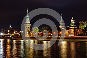 Towers of Moscow Kremlin with glowing reflection of night illumination on water surface of Moskva river