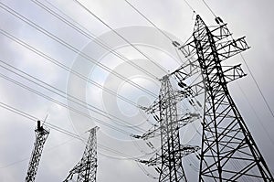 Towers power lines against a cloudy sky background. Electricity