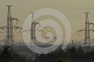 Towers of power lines in the pre-dawn fog