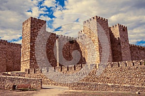 Towers and stone walls facade at the Castle of Trujillo