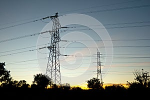 Towers supporting power lines in the twilight