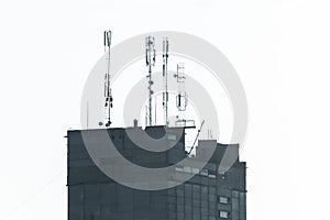 Towers of wireless mobile signal of cellular communication and the Internet communication network on the roof of the silhouette of