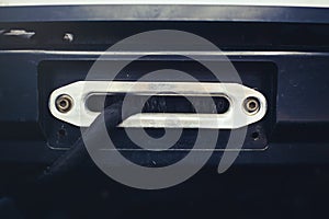 A towing winch with a clevis and a loop on a metal cable mounted on a car