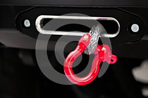 A towing winch with a clevis and a loop on a metal cable mounted on a car for pulling out and evacuating vehicles. Overcoming off-