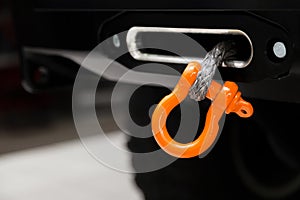 A towing winch with a clevis and a loop on a metal cable mounted on a car for pulling out and evacuating vehicles. Overcoming off-