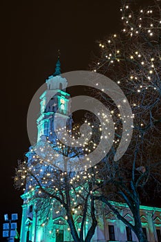 Town hall at Christmas time Kaunas, Lithuania illuminated building and lights on the tree branches, night scene