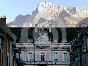 Town hall in La Mure against a high mountain