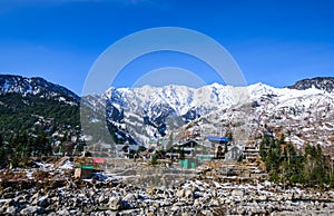 A town in the lap of a snow capped mountain