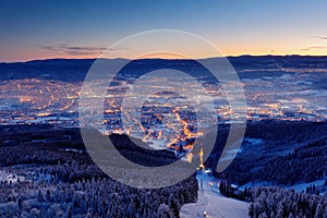 Town Liberec with winter mountain forest before sunrise. Czech early morning snow landscape pink and violet light. Snowy trees wit photo