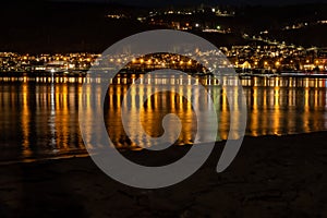 Town lights reflecting in a lake at night