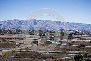 Town and marshland in south San Francisco bay area; Mission, Monument and Allison peaks in Diablo mountain range in the background