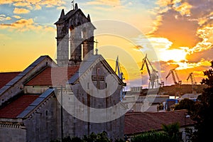 Town of Pula stone church and shipyard cranes sunset view