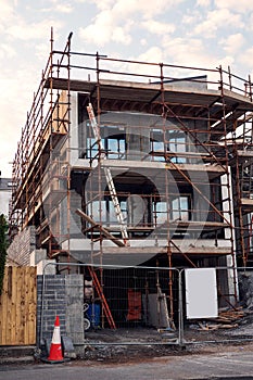 Town residential house building. Modern home construction site with scaffolding. Nobody