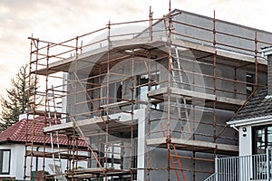 Town residential house building. Modern home construction site with scaffolding. Nobody