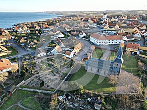 a town with some buildings near water and a beach near it