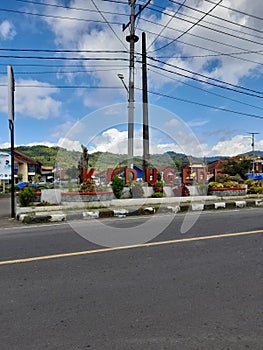 Town square atmosphere during the day is on the side of the road with greenery around