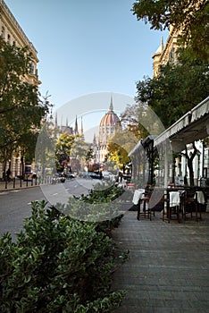 Town street with sidewalk cafe with view to Hungarian paliament building.