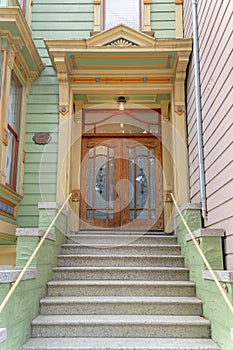 Townhouse entrance exterior with concrete doorsteps and large wooden double door