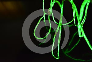 Toxic green lime lighting with a specific pattern. Woven filaments, cable, wires with outgoing light. Neon electroluminescent wire