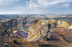 Toxic lake in abandoned open pit copper mine and waste heaps near Kampia, Cyprus photo