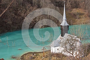 Toxic waste waters from a copper and gold mine submerge village. Abandoned orthodox church on lakeside