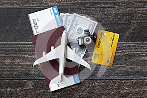 Toy airplane, Air Ticket, credit cards, dollars and passport on wooden table. Travel concept