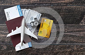 Toy airplane, Air Ticket, credit cards, dollars and passport on wooden table. Travel concept