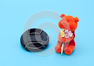 Toy bear and lid from the lens on a blue