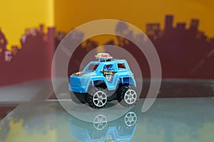 Toy big wheel car in police concept on blur city background